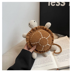 Close-up of handmade crochet turtle bag showing brown knit texture and white stitching
