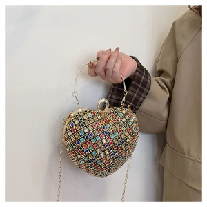 Macro shot of colorful rhinestone heart evening bag with gold metal handle and details