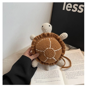 Detail shot of a handmade crochet turtle bag with textured brown shell and woven strap