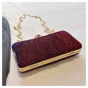 Detail of burgundy evening clutch with sequin pleats, gold metal frame, and thin chain
