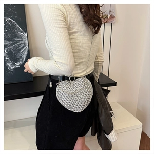 Detail of silver heart-shaped evening bag with rhinestones and metal chain strap