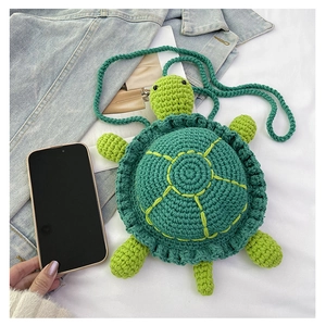 Detail of hand-crocheted green turtle crossbody bag with shell pattern and yarn strap