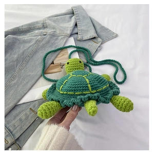 Detail of green knitted turtle bag showing handmade crochet texture and shell pattern