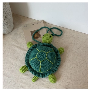 Detailed view of green crochet turtle bag featuring handmade knitted texture and design