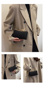 Macro detail of black pleated clutch with gold ring clasp and glittering texture finish