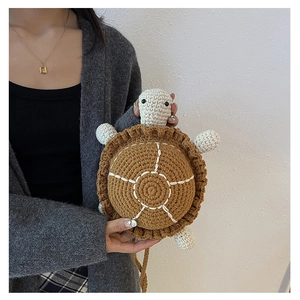 Detailed view of handmade crochet turtle bag with textured brown shell and woven strap
