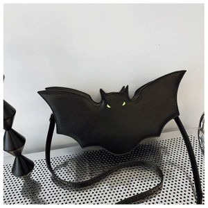 Detail of bat-shaped gothic shoulder bag with vibrant neon green eye accents