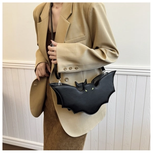Detail of a black bat-shaped PU leather crossbody bag with small yellow eye accents