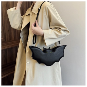 Close-up of the bat-shaped crossbody bag featuring yellow eyes and fine leather texture