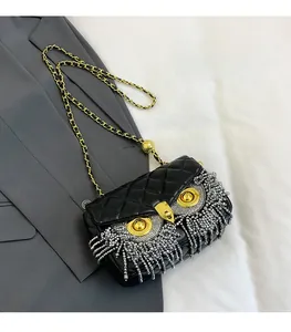 Detail of owl design on quilted leather bag with golden chain and beaded fringe