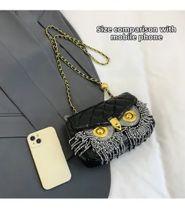 Detailed comparison of the owl crossbody bag size with a mobile phone on grey suit