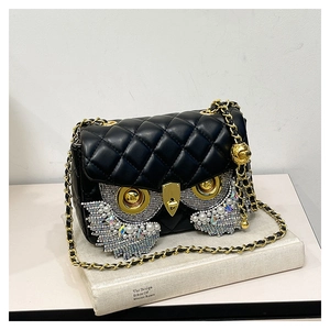 Detailed close-up of quilted black leather owl bag with sparkling rhinestones and pearls