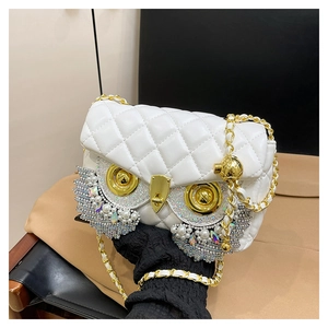 Detail of owl-shaped crossbody bag with quilted white PU leather and rhinestone eyes