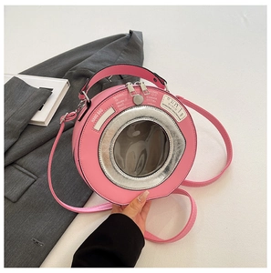 Close-up of pink washing machine shaped handbag with transparent window and zipper detail