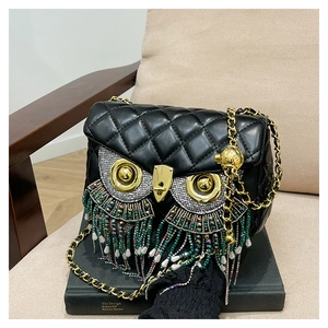 Detail of owl-shaped crossbody bag with quilted leather and colorful beaded tassels