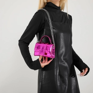 Mini candy-colored metallic pink crossbody bag with silver chain strap on model