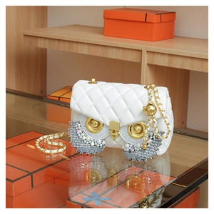 Detail of owl quilted crossbody bag with rhinestone eyes and gold chain strap