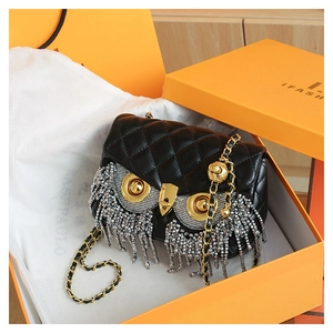 Detailed view of quilted leather owl bag with sparkling silver bead fringe and chain strap