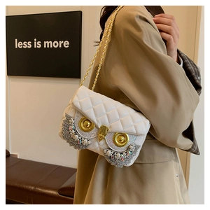 Detail of owl-shaped crossbody bag featuring rhinestones, pearls, and quilted leather