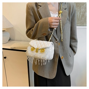 Quilted white shoulder bag with owl-shaped design and rhinestone fringe detail