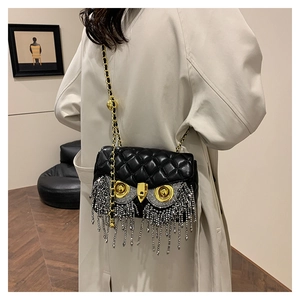 Detail of owl motif with crystal tassels on a black quilted leather crossbody bag