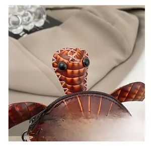 Gros plan d'un porte-monnaie tortue en cuir montrant les coutures roses et la texture