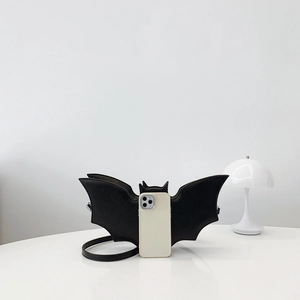 Quirky black bat wing crossbody bag in PU leather shown with smartphone for size reference
