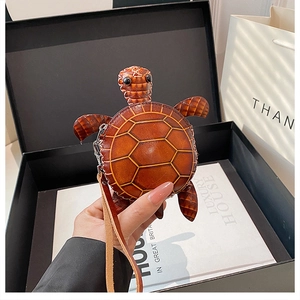 Vue détaillée d'un porte-monnaie tortue en cuir marron avec surpiqûres et fermeture éclair