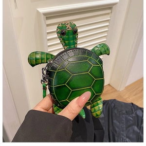 Gros plan détaillé d'un mini porte-monnaie tortue en cuir vert avec un crochet métallique