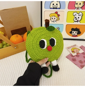 Detail of green apple crochet bag featuring cartoon eyes and 3D legs with cute shoes