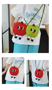 Close-up of handmade knit apple-shaped crossbody bag with cartoon eyes and feet detail