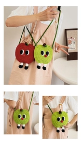 Detail of handmade knit apple crossbody bags with cute 3D cartoon eyes and legs
