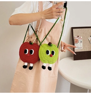 Detail view of handmade crochet apple-shaped mini bags with cute 3D features and straps