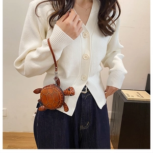 Détail du petit porte-monnaie tortue en cuir marron avec surpiqûres et dragonne
