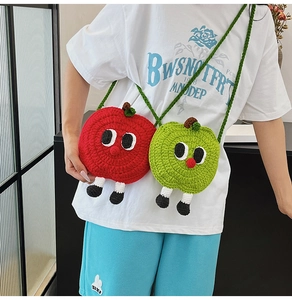 Close-up of handmade crochet apple-shaped mini crossbody bags with cartoon features