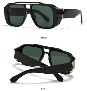 Detailsicht der großen schwarzen Sonnenbrille mit Goldakzenten und grünen Gläsern