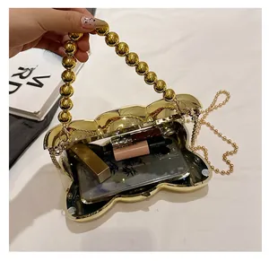 Vue détaillée du sac papillon doré montrant l'espace pour téléphone et rouge à lèvres