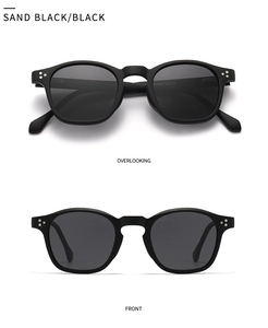 Close-up of matte black round sunglasses featuring classic triple rivet detail and grey lenses