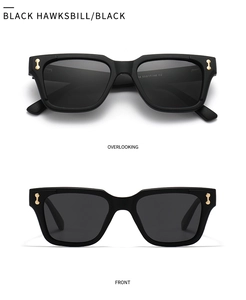 Detail view of black polygon sunglasses with signature gold dumbbell metal hardware