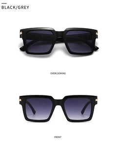 Detail view of square black sunglasses with grey gradient lenses and gold metal accents
