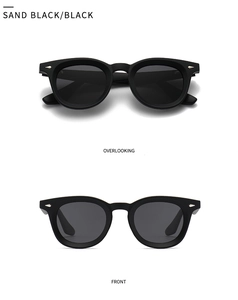 Detail view of matte black round frame sunglasses with triangular silver metal accents