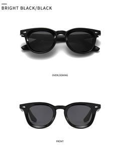 Close-up of shiny black round polarized sunglasses with silver arrow detail on the frame