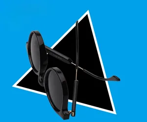 Detail view of glossy black sunglasses with golden metal temples and model code engraving
