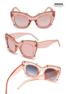 Detailed view of red cat-eye sunglasses with gradient pink lenses and gold rivet accents