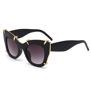 Chic black oversized cat-eye sunglasses with gold metal claw accents and purple lenses