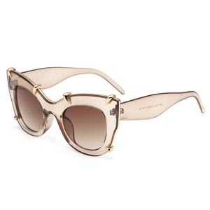 Cat eye sunglasses with champagne frames and gold claw accents on a white background