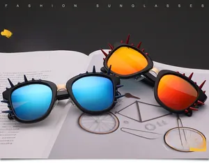 Close-up of polarized sunglasses with blue and orange lenses and bold spiky decorations