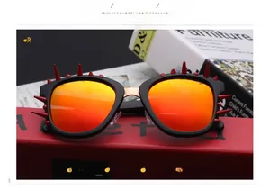Detail of punk sunglasses with black matte frames and sharp red decorative spikes