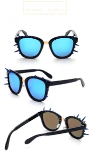 Detail view of square sunglasses featuring unique blue spikes and a gold metal bridge