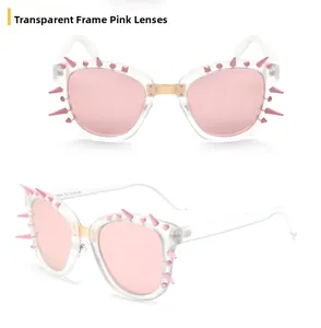 Detail view of transparent pink sunglasses with punk style studs and gold metal bridge